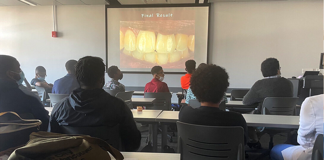 A classroom filed with young Black men, listening to a lecture about dentistry