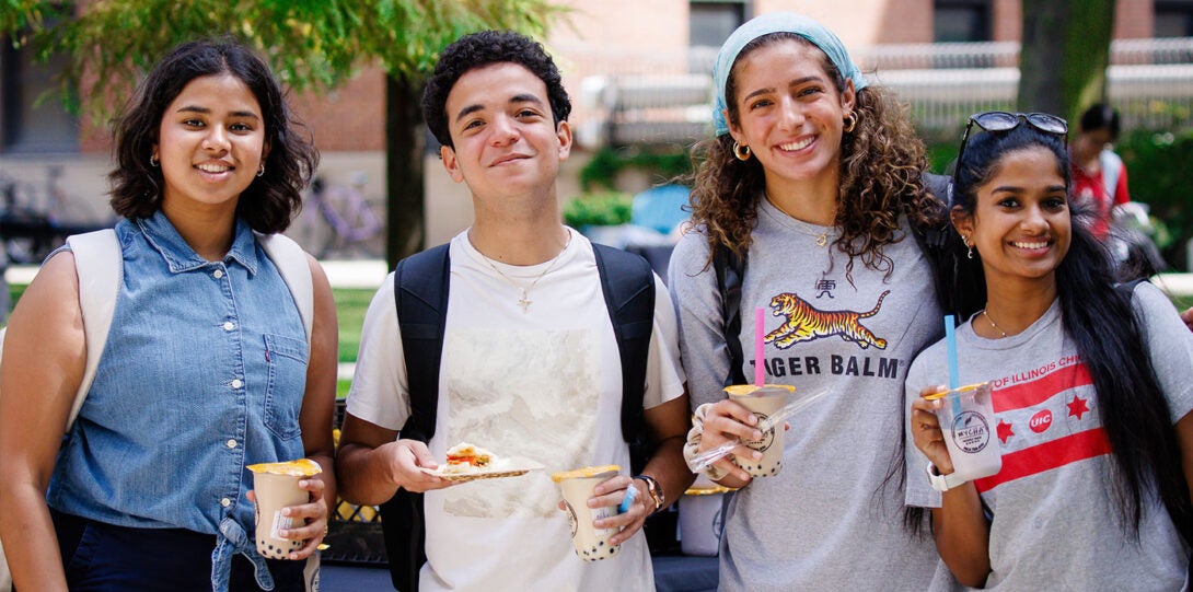 four young health sciences students smiling and holding cups of cool boba tea