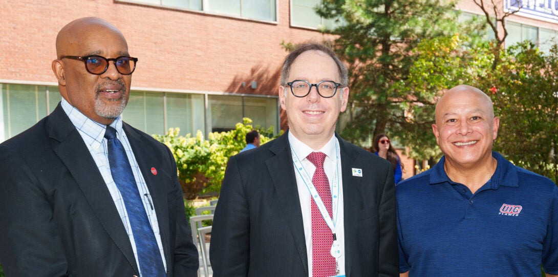 At left, an African American man in a dark blue suit. At center, a white man in a dark gray suit. At right, a Latinx man wearing a dark blue shirt.